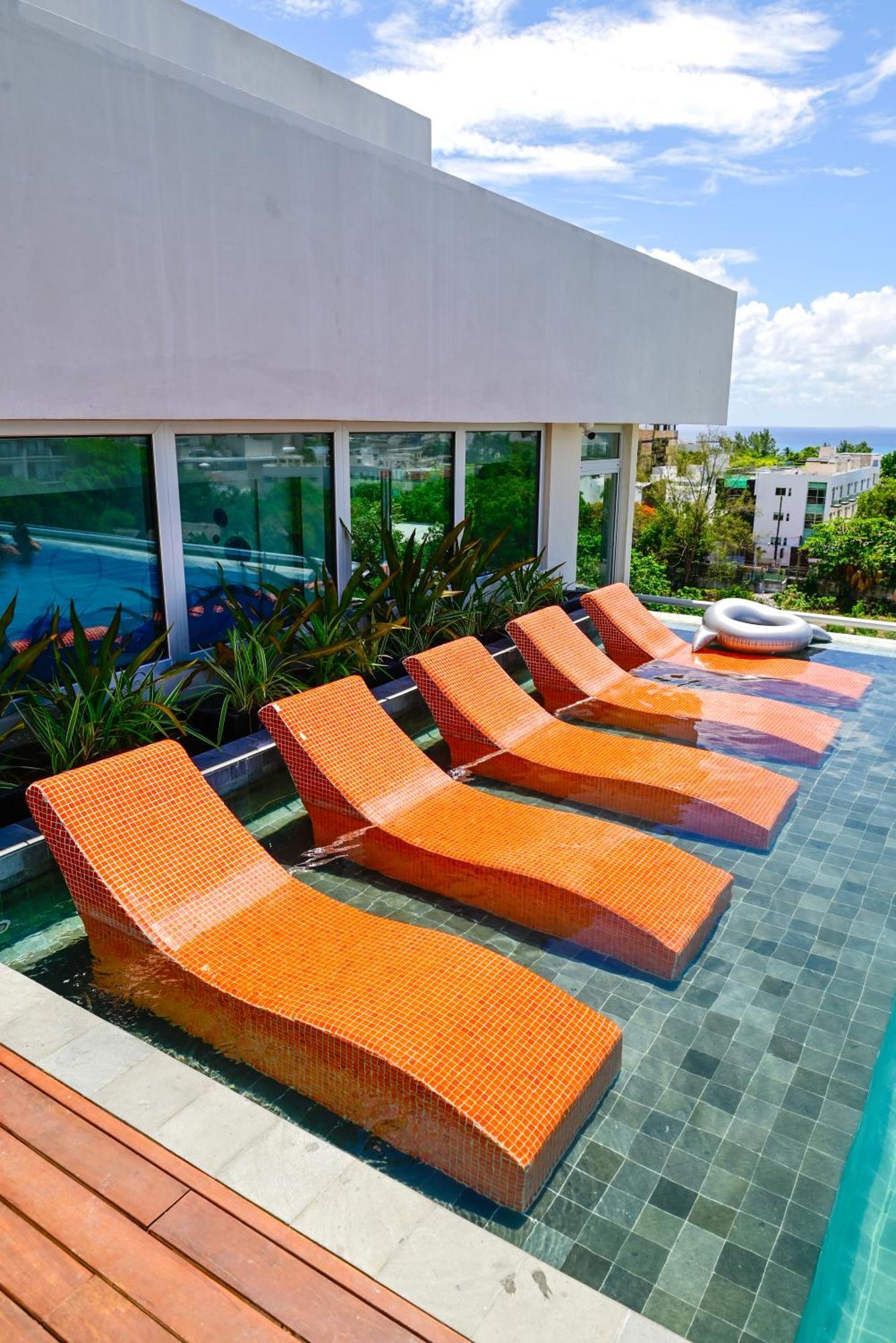 ホテル Aloft プレヤデルカーメン エクステリア 写真 Sunbathing chairs at a pool